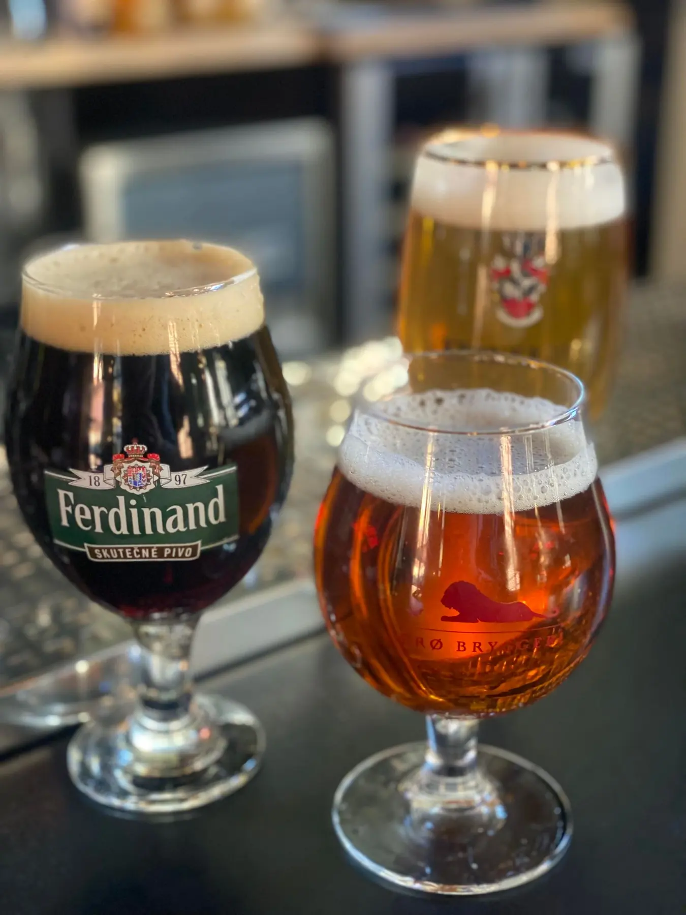 Tre forskellige fadøl i glas på baren