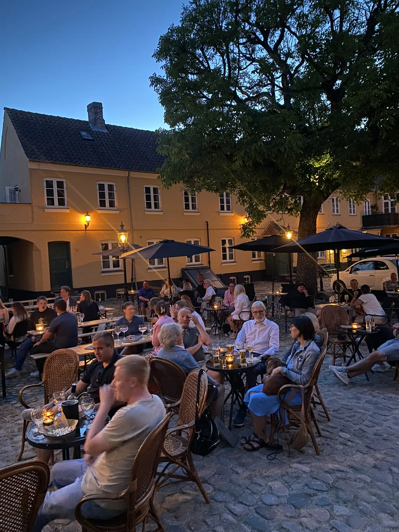 Gården i skumringen med gæster