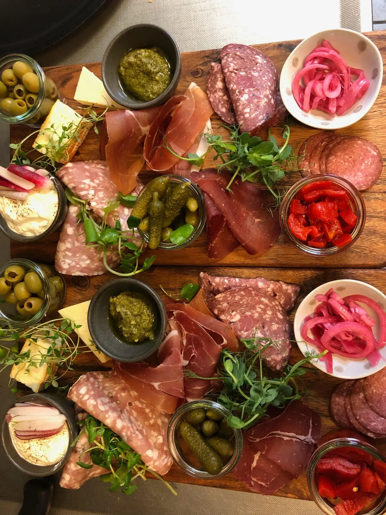 Tapasbræt med pølser, oliven, syltede grøntsager og dip